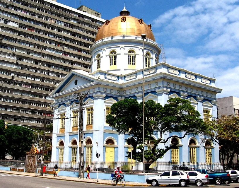 Fachada histórica da Assembleia Legislativa de Pernambuco no centro do Recife, com cúpula dourada e arquitetura neoclássica.