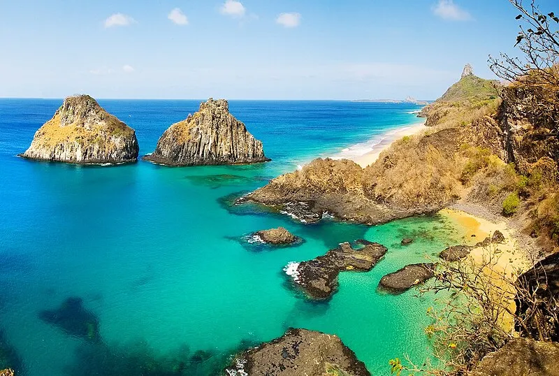 Vista aérea da Baía dos Porcos em Fernando de Noronha com águas cristalinas e formações rochosas