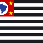 Bandeira do estado de São Paulo com listras pretas e brancas, um retângulo vermelho no canto superior esquerdo contendo o mapa do Brasil em azul e quatro estrelas amarelas