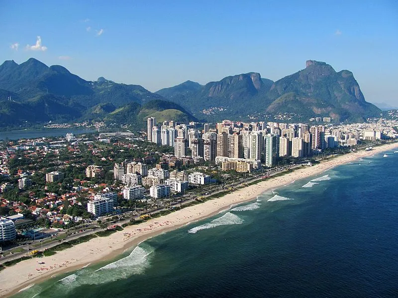 vista aérea da Barra da Tijuca no Rio de Janeiro com praia e montanhas ao fundo