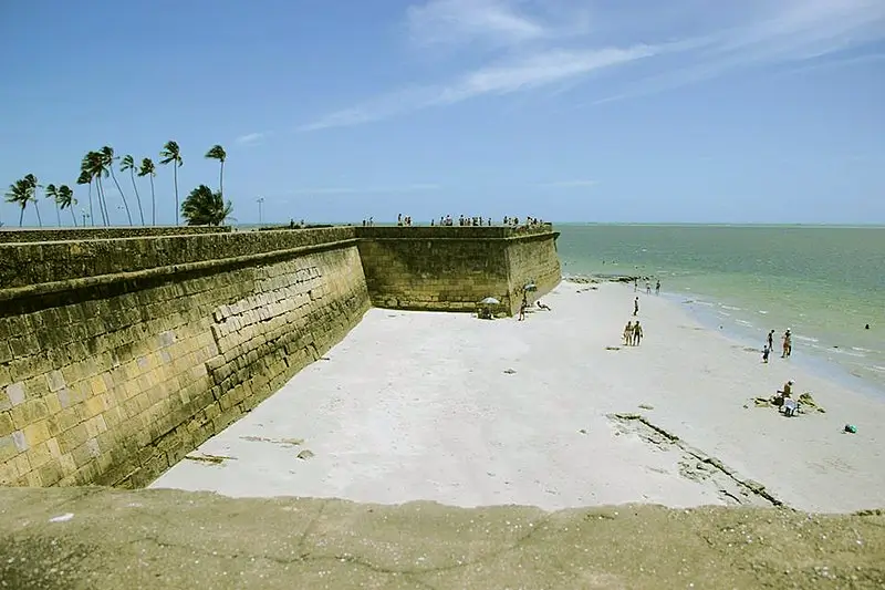 Forte Orange na Ilha de Itamaracá, em Pernambuco, visto da praia com turistas caminhando