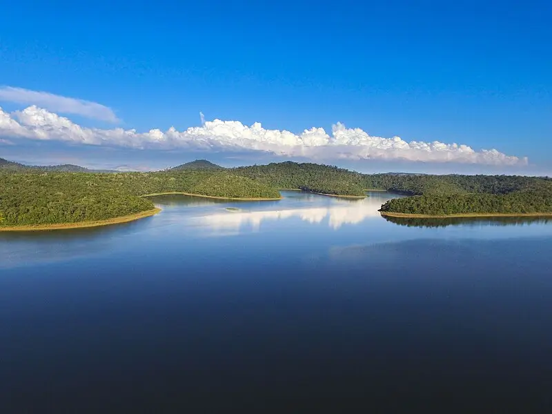 Vista aérea do Parque Estadual do Rio Doce, com lagoas de águas calmas cercadas por vegetação nativa e céu azul com nuvens
