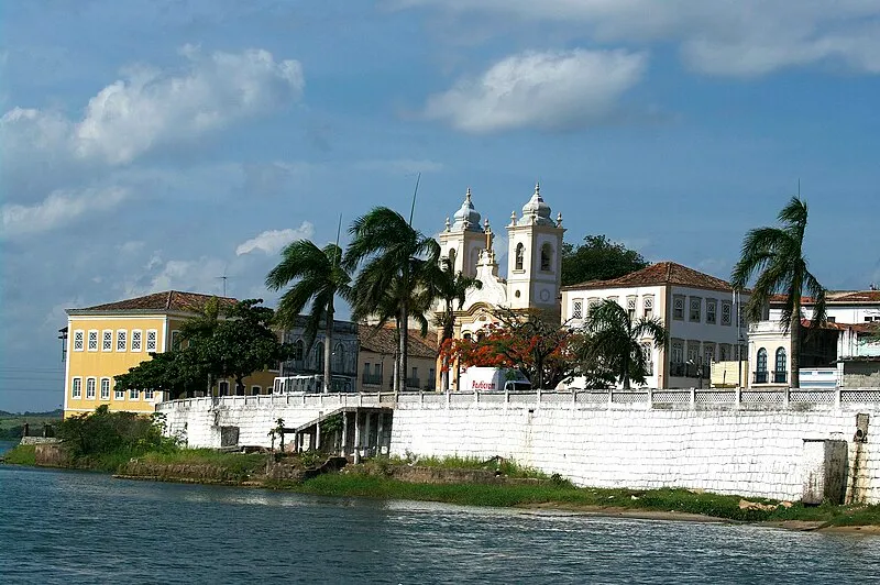 Vista do centro histórico de Penedo com igreja colonial e casario à beira do rio São Francisco