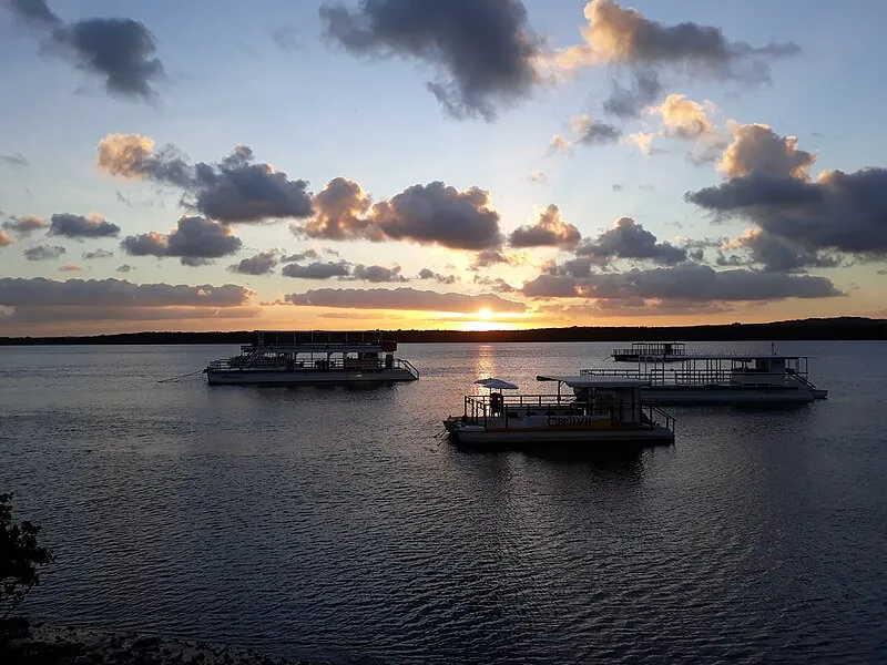 Pôr do sol na praia fluvial do Jacaré em Cabedelo com barcos no rio Paraíba