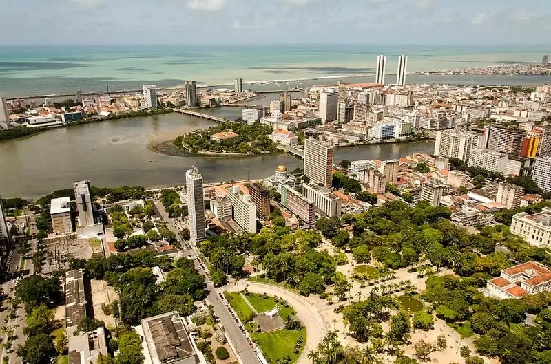 Vista aérea do centro do Recife, mostrando o Marco Zero, rios e arranha-céus à beira-mar em Pernambuco.