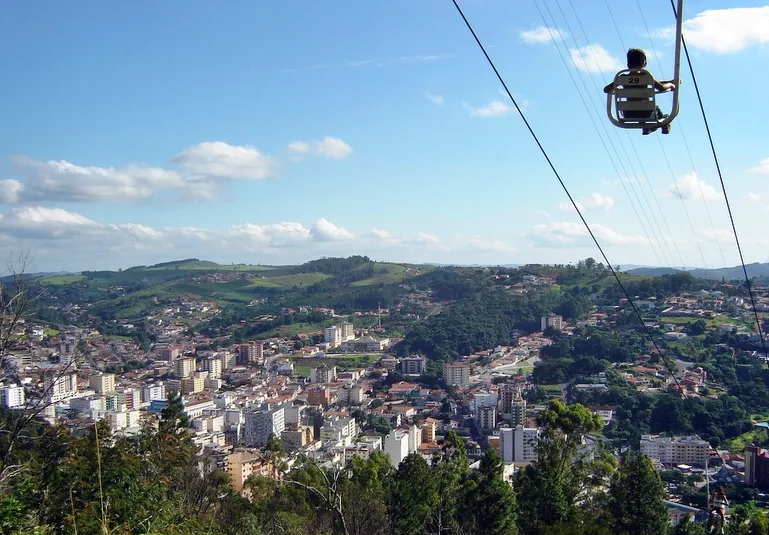 Vista aérea de Serra Negra com teleférico e paisagem urbana ao fundo