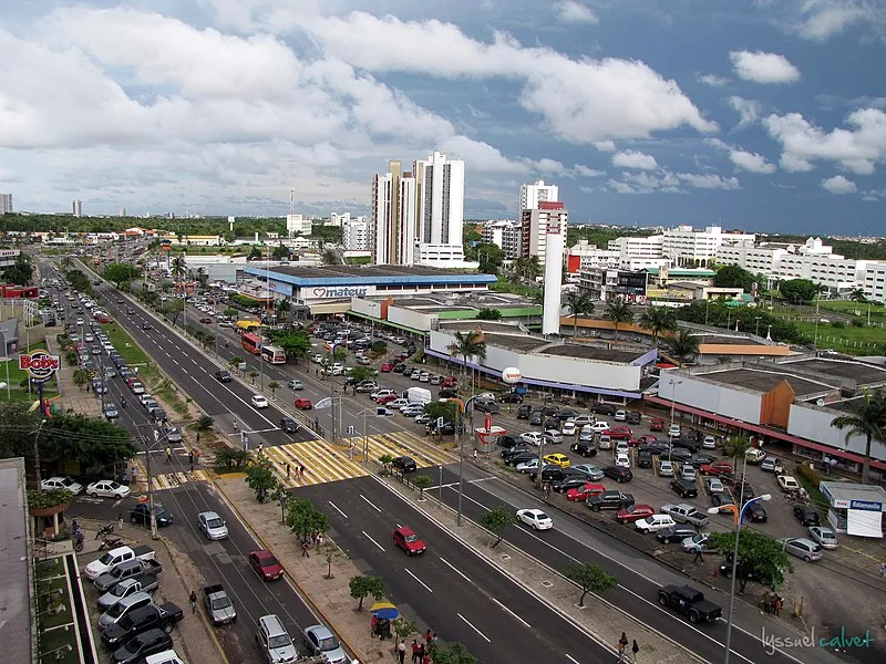 Vista aérea da Avenida Colares Moreira em São Luís com grande movimento de carros e prédios ao fundo
