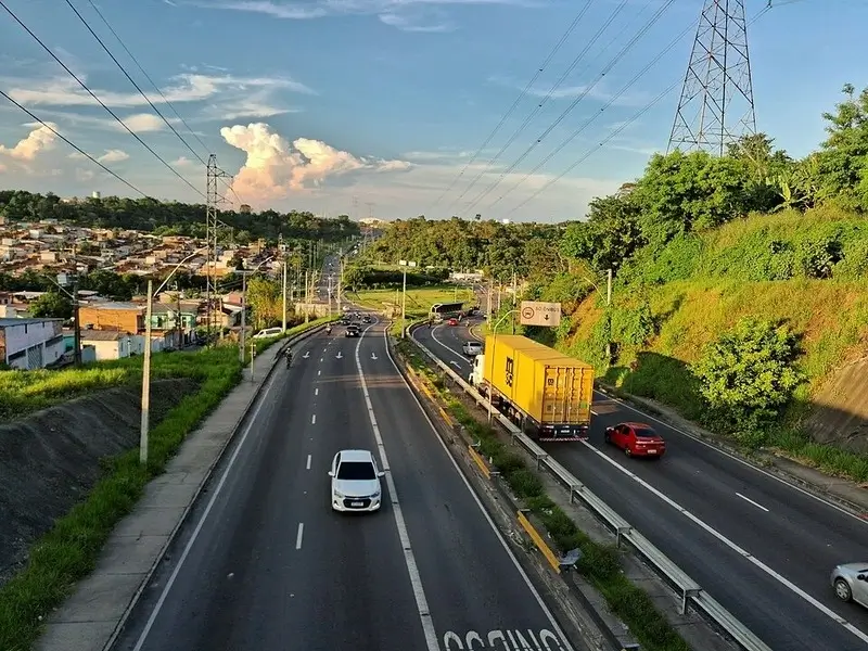 Avenida Governador José Lindoso em Manaus com tráfego urbano e área verde ao redor, importante via da capital amazonense.