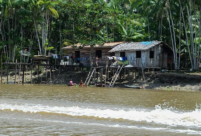 Casas de madeira sobre palafitas às margens do rio em comunidade ribeirinha no Pará