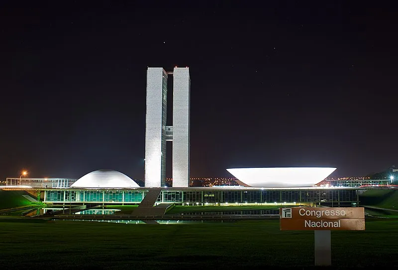 Congresso Nacional de Brasília iluminado à noite, com as cúpulas e torres destacadas