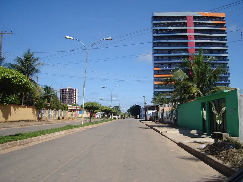 Avenida urbana em Ji-Paraná com prédios residenciais e céu azul