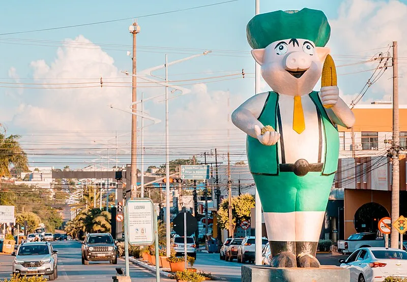 Estátua do mascote Luquinha segurando milho em avenida de Lucas do Rio Verde