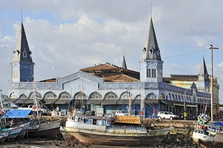Fachada do Mercado Ver-o-Peso com barcos ancorados em frente, em Belém do Pará