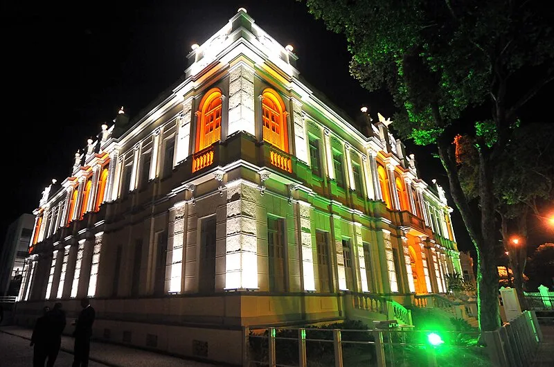 ALT: Fachada iluminada do Museu da Gente Sergipana à noite em Aracaju