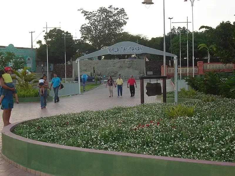 Entrada da Orla Taumanan com jardim florido e o Monumento aos Pioneiros ao fundo em Boa Vista.