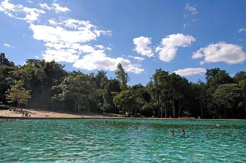 Piscina natural do Parque Nacional de Brasília com água cristalina e visitantes nadando, cercada por vegetação nativa