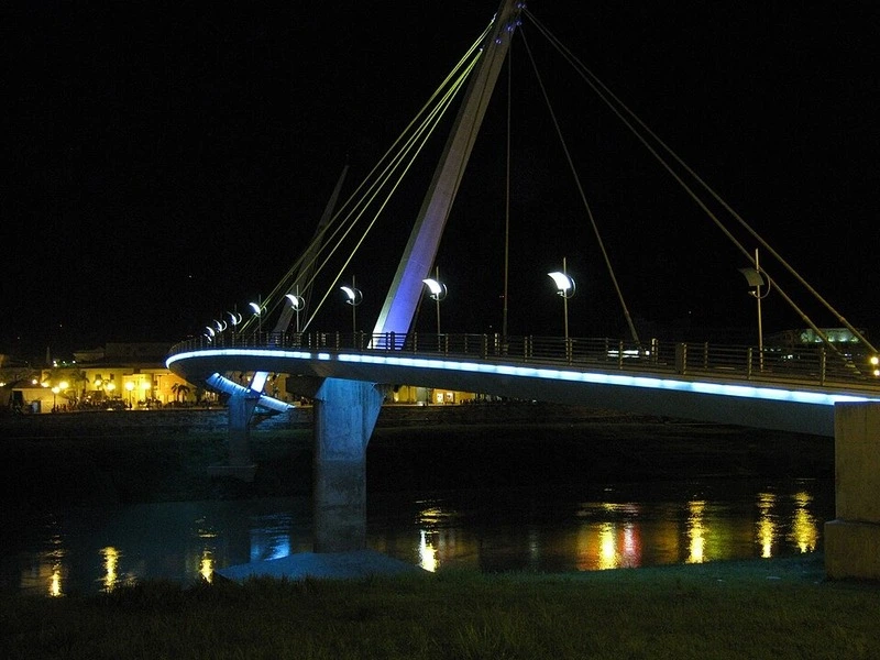 Ponte pedonal iluminada sobre o rio Acre em Rio Branco durante a noite