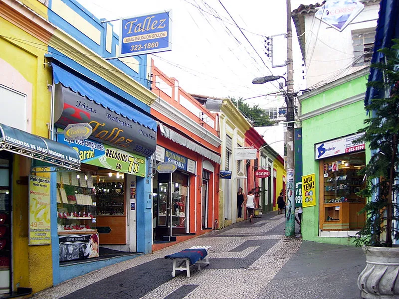 Vista da Rua Cândido Mariano em Cuiabá com lojas coloridas e calçada decorada