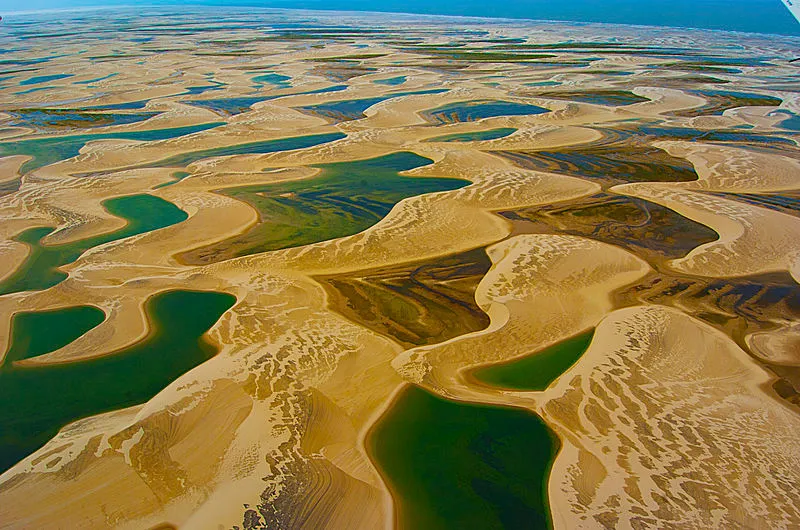 Vista aérea dos Lençóis Maranhenses com dunas e lagoas esverdeadas no Maranhão