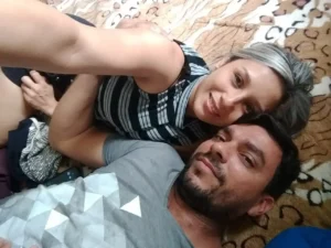 Casal deitado lado a lado sorrindo, em momento de descanso e carinho