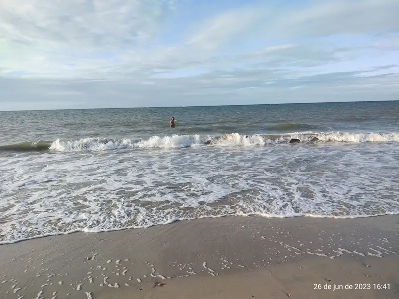 Praia de Cumbuco com ondas suaves e céu nublado em Caucaia (CE)