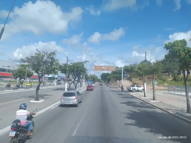 Trecho urbano da BR-101 em Abreu e Lima com veículos, motociclistas e céu azul