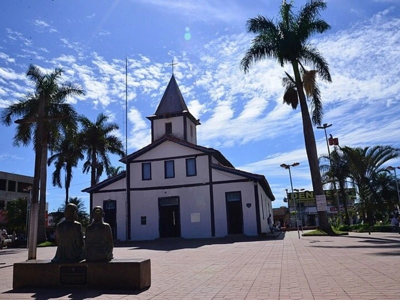 Igreja Matriz de Aparecida de Goiânia com palmeiras ao redor e esculturas na praça central