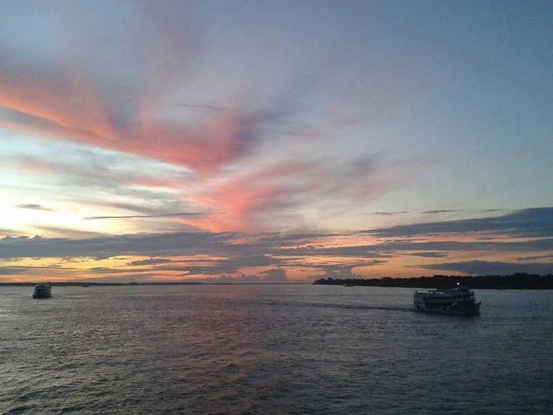 Pôr do sol no Rio Amazonas com embarcações próximas a Parintins no Amazonas