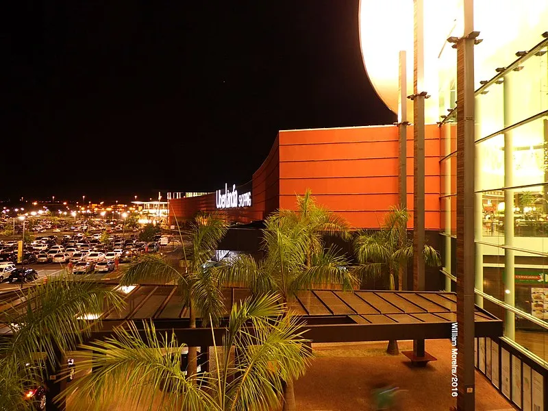 Fachada iluminada do Uberlândia Shopping à noite