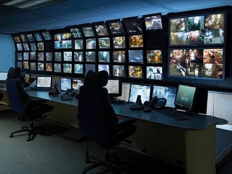 entral de monitoramento com diversas telas exibindo câmeras de segurança e rastreamento de veículos