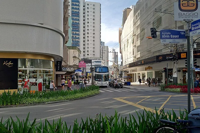 Esquina das avenidas Brasil e Alvin Bauer no centro de Balneário Camboriú com pedestres e comércios