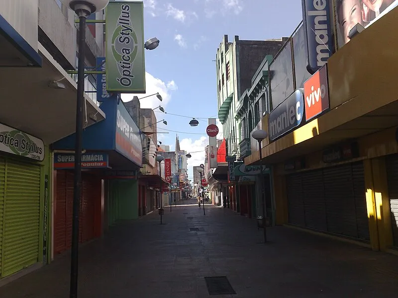 Calçadão do comércio em Rio Grande RS com lojas e fachadas coloridas.