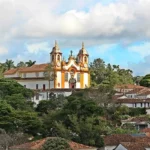 Vista da Igreja Matriz de Santo Antônio em Tiradentes, Minas Gerais, cercada por casas coloniais e vegetação