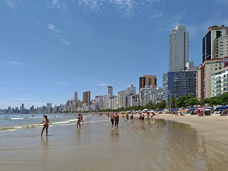 Banho de mar e prédios altos na Praia Central de Balneário Camboriú em dia ensolarado