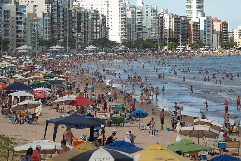 Praia do Morro em Guarapari ES, movimentada com turistas e prédios ao fundo
