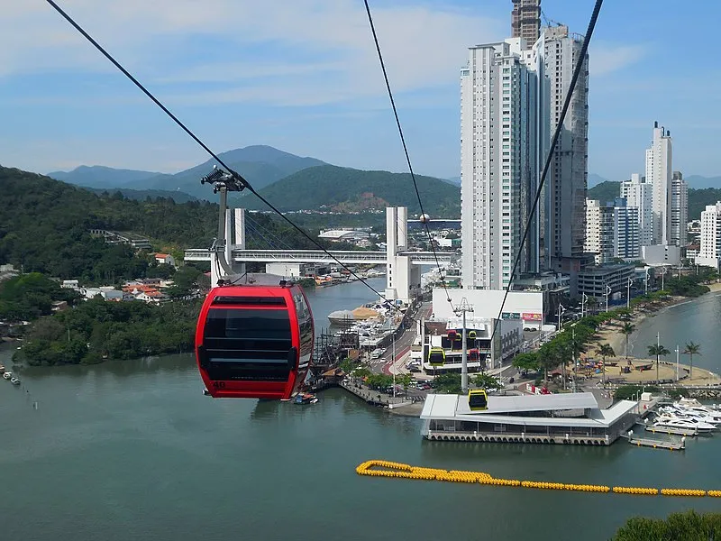 Bondinho do Parque Unipraias passando sobre o rio em Balneário Camboriú com prédios ao fundo