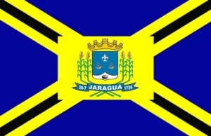 Bandeira oficial do município de Jaraguá, Goiás, com brasão central em fundo azul e amarelo