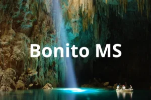 Gruta do Lago Azul em Bonito MS com feixe de luz e turistas em bote
