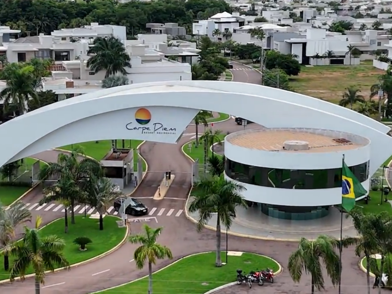 Entrada principal do Condomínio Carpe Diem em Sinop com arquitetura moderna e paisagismo tropical