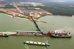 Vista aérea do Porto de Barcarena, no Pará, com navios atracados e área industrial ao fundo