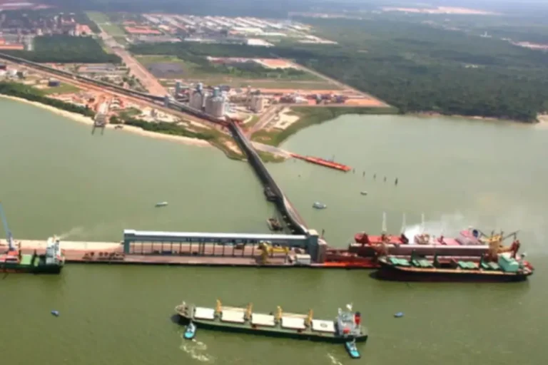 Vista aérea do Porto de Barcarena, no Pará, com navios atracados e área industrial ao fundo