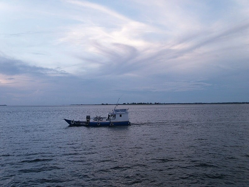 Barco navegando no Rio Tapajós em Santarém ao entardecer com céu nublado