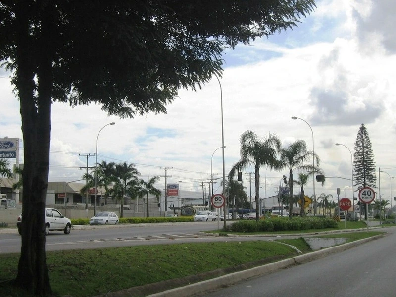 Trecho urbano da BR-101 na Região Metropolitana de Vitória, com canteiro central arborizado e sinalização viária.