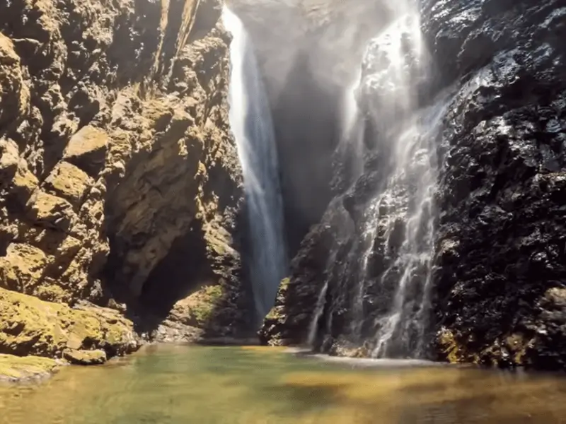 Cachoeira do Dragão com duas quedas d’água entre paredões rochosos na Chapada dos Veadeiros.