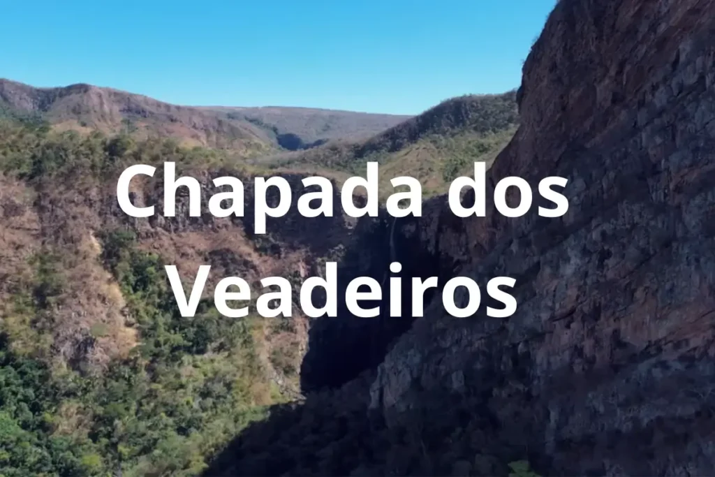 Vista aérea de cânion rochoso na Chapada dos Veadeiros com vegetação do cerrado e céu azul.
