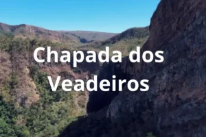Vista aérea de cânion rochoso na Chapada dos Veadeiros com vegetação do cerrado e céu azul.
