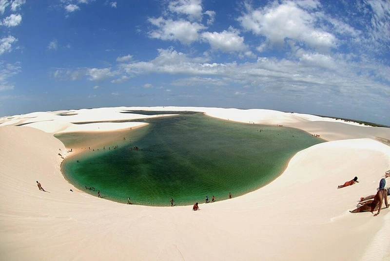 Lagoa da Gaivota verde-esmeralda entre dunas brancas nos Lençóis Maranhenses em dia ensolarado.