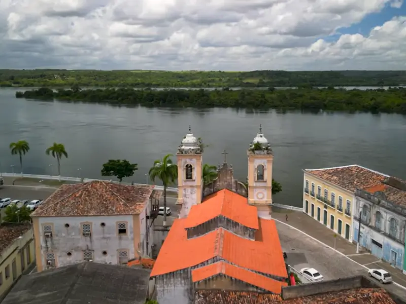 Vista aérea da igreja histórica de Penedo com o Rio São Francisco ao fundo.