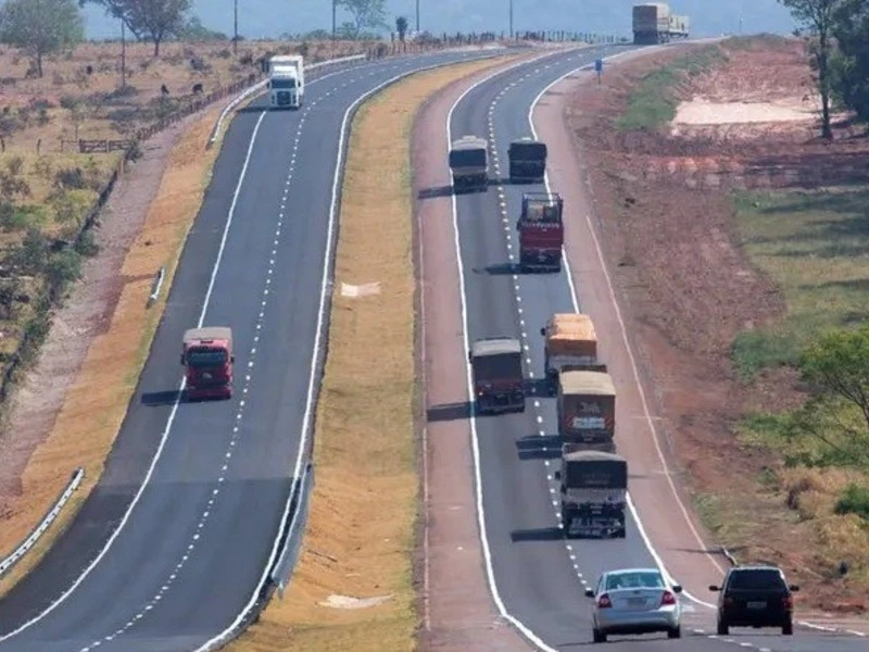 Trecho duplicado da BR-163 no Mato Grosso do Sul com fluxo intenso de caminhões e veículos leves em pista dupla.