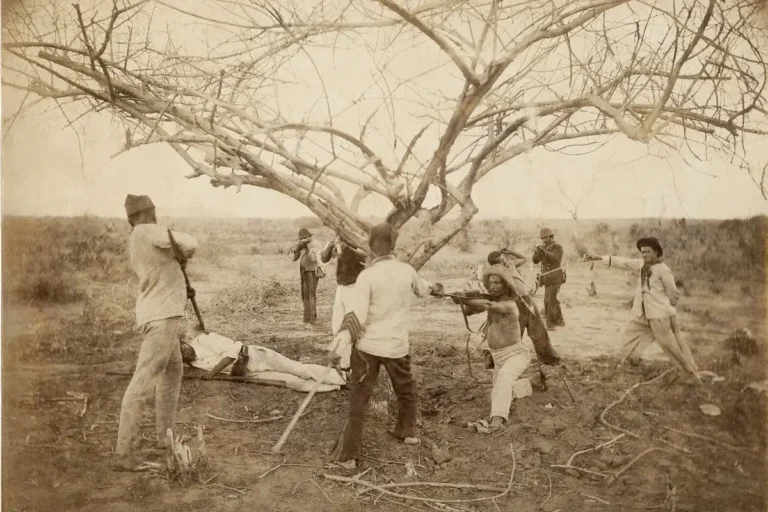 Reconstituição histórica da Guerra de Canudos, no interior da Bahia, retratando confronto armado no sertão brasileiro no final do século XIX.